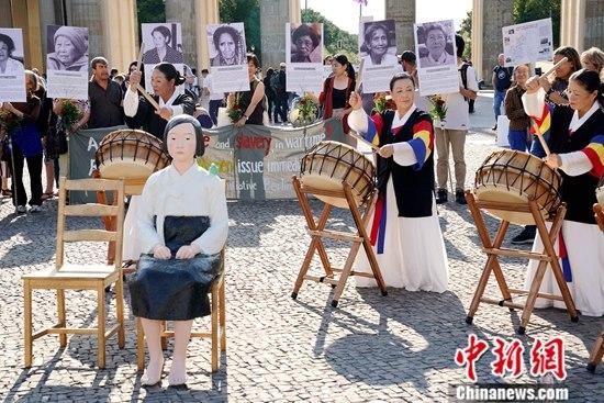 资料图：在德的韩国和日本民间团体于第七个世界“慰安妇”纪念日之际在柏林勃兰登堡门前举行集会，再次敦促日本政府正式向“慰安妇”制度暴行受害者道歉，并作出赔偿。一座“和平少女像”亦出现在当天的活动现场。<a target=
