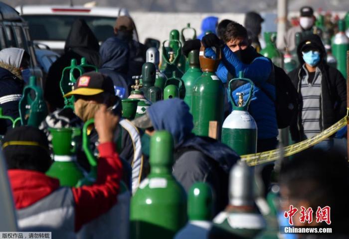 资料图：秘鲁第二大城市阿雷基帕，新冠肺炎患者的家属排队给医用氧气瓶充电。