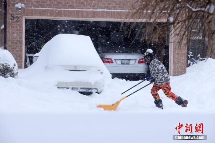 当地时间1月17日，加拿大多伦多，居民清理住宅门前的积雪。当日，严重的暴风雪天气席卷加拿大安大略省以及魁北克省的广泛地区，造成多地交通、市政服务等受到影响。 <a target=