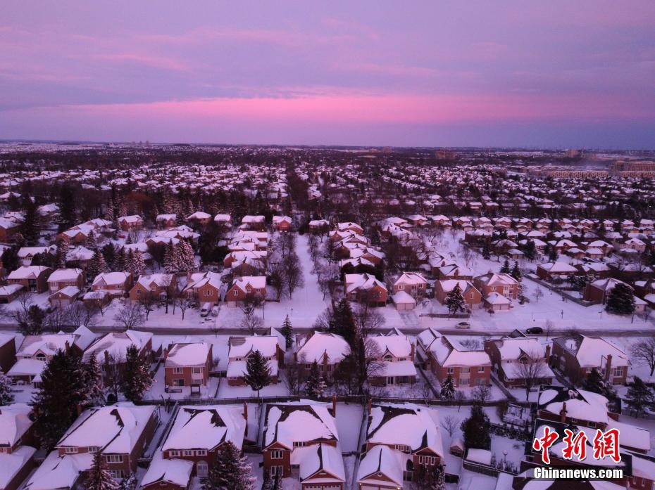 当地时间1月17日，加拿大多伦多，晚霞映衬着被白雪覆盖的居民区。当日，严重的暴风雪天气席卷加拿大安大略省以及魁北克省的广泛地区，造成多地交通、市政服务等受到影响。 <a target=