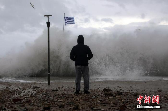 当地时间2021年12月11日，希腊古法利罗，暴风雨中，民众观看海浪冲击码头。 图片来源：ICphoto