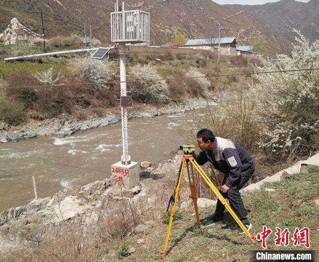 图为常福昌测量河流水面高程。(资料图) 甘肃省水利厅供图