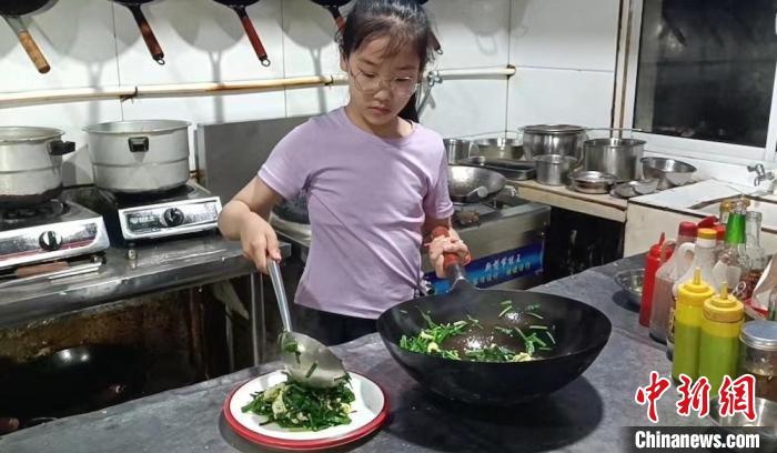 灶台前的孙佳瑞有模有样，被赞是“小厨师”。　孙权 摄