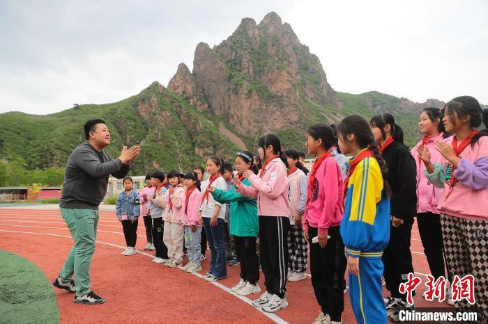 图为龚新亮指导学生做音乐游戏。　曹建雄 摄