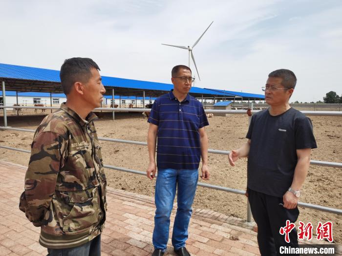 图为李旭光(右一)指导大甸子村改良点建设。　胡立忠 摄