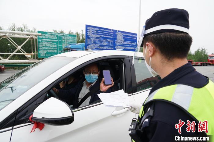 图为城东公安分局执勤民警查验“两码一报告”。　马铭言 摄
