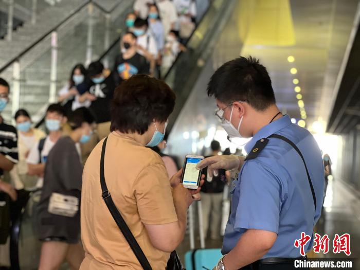 工作人员为旅客答疑。　林园园 摄