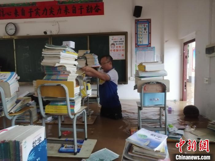图为金田三中教师趟水搬运书籍。　金田三中供图