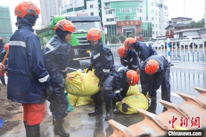 图为救援人员将沙袋放入铲车。　李袁辉 摄
