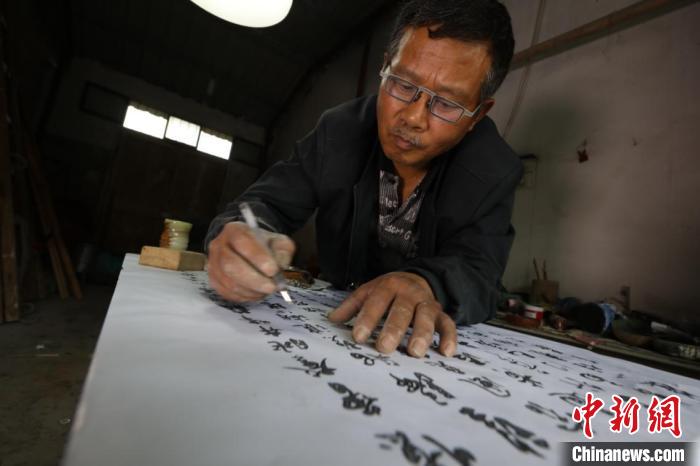 章金桂在石碑上仔细进行勾描打底 吴建勋 摄 摄