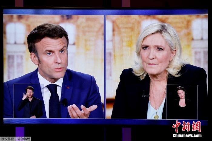 当地时间4月20日晚，争取连任的法国总统马克龙与极右翼党派“国民联盟”总统候选人玛丽娜·勒庞进行2022年法国总统选举电视辩论，聚焦经济与民生议题。图为两人当晚辩论的电视画面。