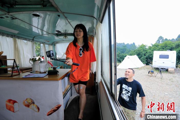 杨谙谙和哈力木·赛力克拍摄视频介绍露营地内的一辆服务车。　王磊 摄
