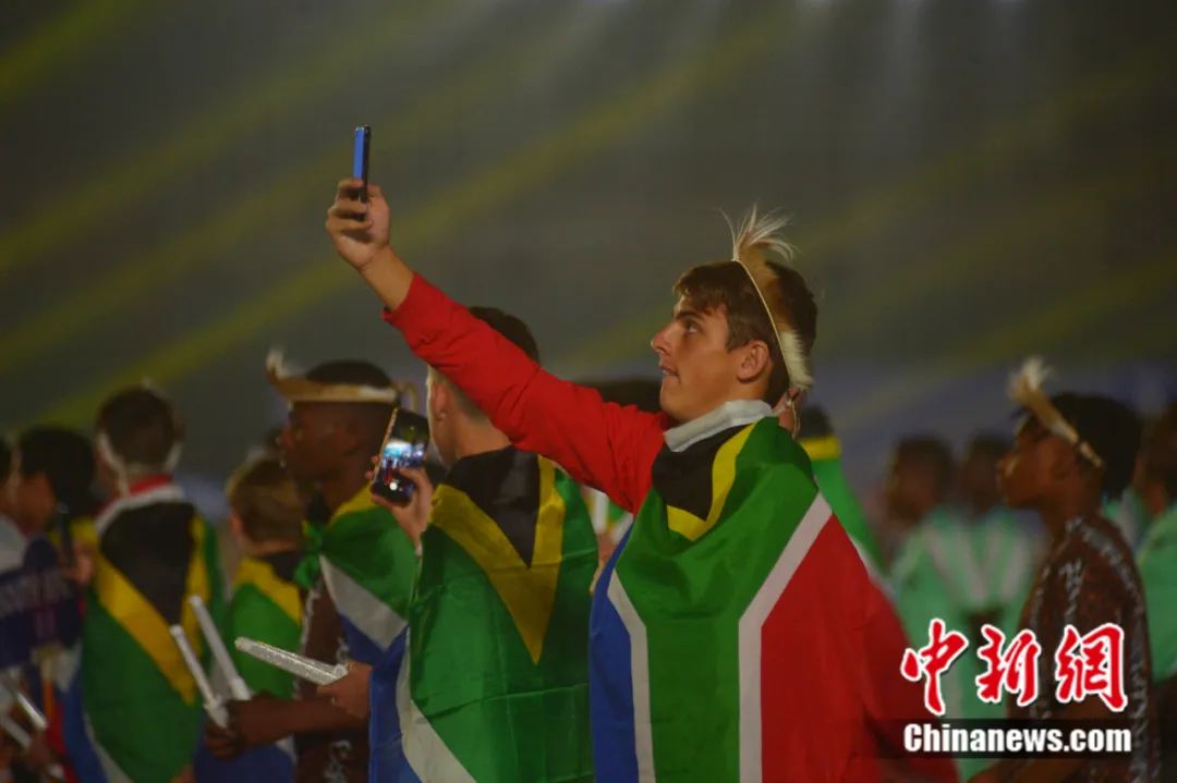 2019年8月，一名来自南非足球队的队员在青岛举行的2019“哥德杯中国”世界青少年足球赛开幕式会场举起手机拍照。<a target=