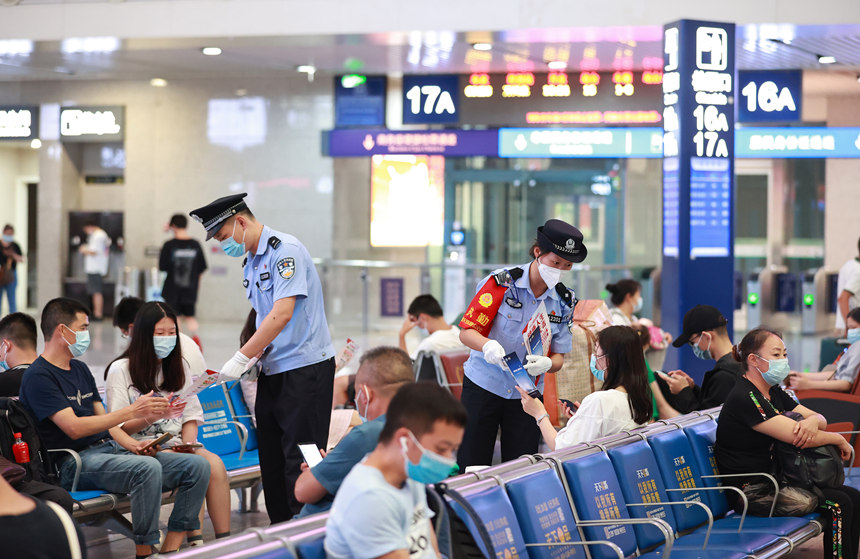 6月23日，民警在重庆北站候车厅向旅客发放禁毒宣传资料。胡勇摄