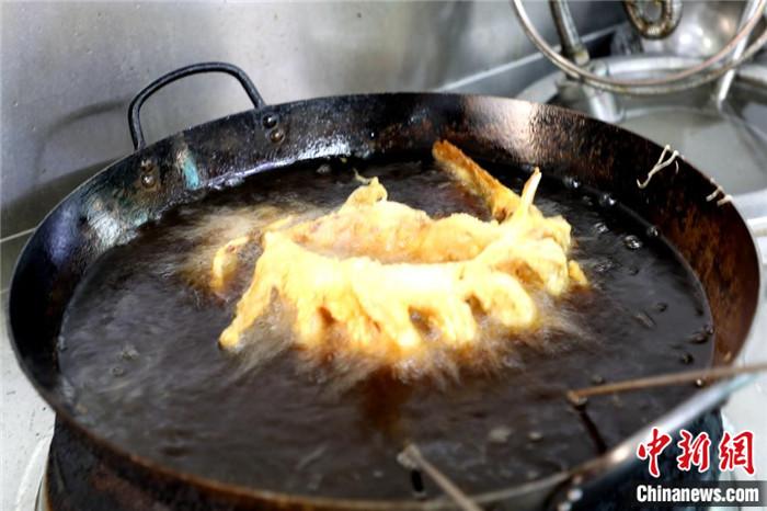 鲤鱼在油锅中定型。