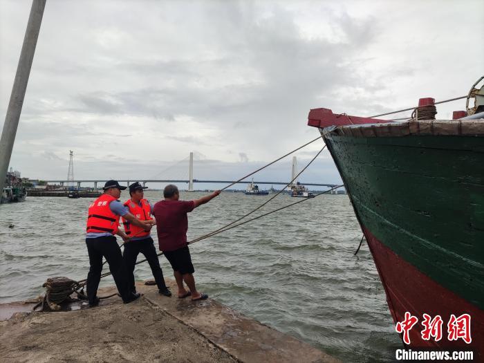 民警在文昌市清澜港码头联合渔船民进行渔船加固防台风。　黄涛 供图