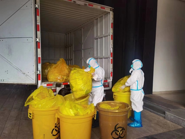 工作人员正对大渡口隔离酒店内产生的医疗废物进行处置转运。重庆市生态环境局供图