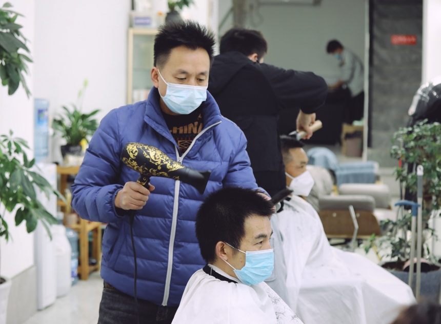 在沙坪坝区覃家岗步行街，一理发店为市民提供服务。郭思云摄
