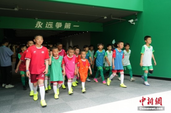 图为国安小球员和青海玉树的藏族少年们一起走进球场。<a target=