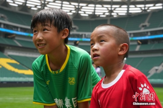 图为国安小球员陈小北和7岁的俄金仁增在一起观看场内播放的视频。<a target=