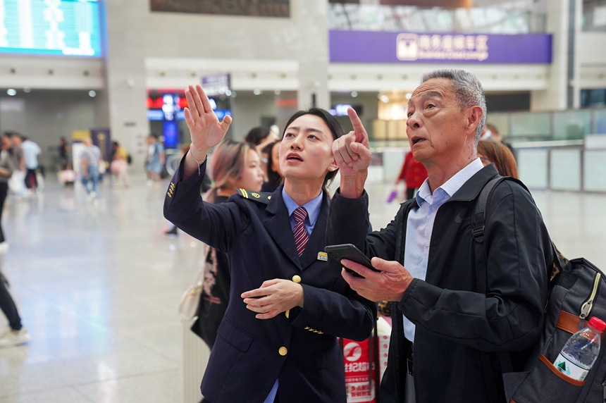 重庆北站，工作人员为旅客作引导。汪亮摄